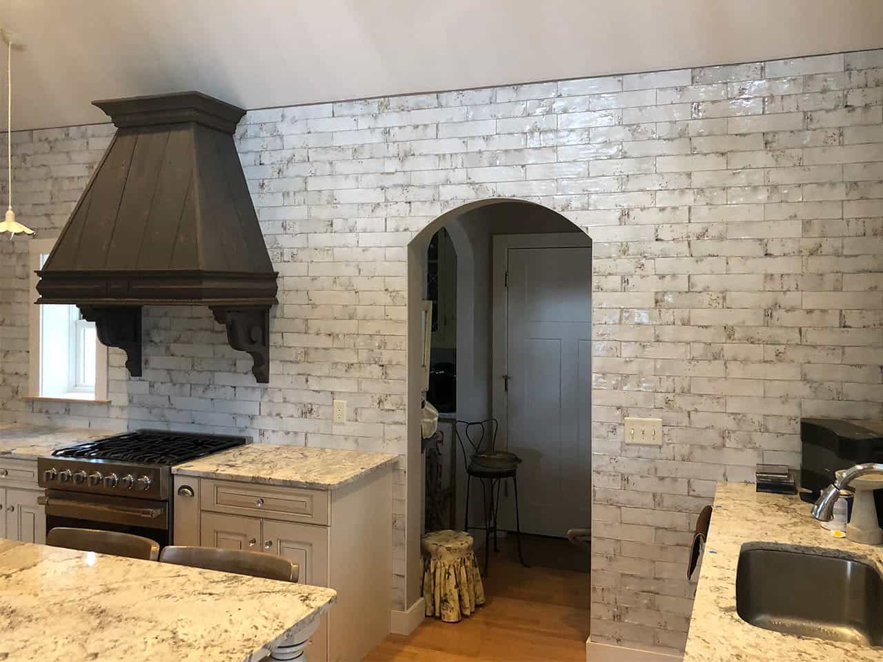 A kitchen with custom tile archway and wall